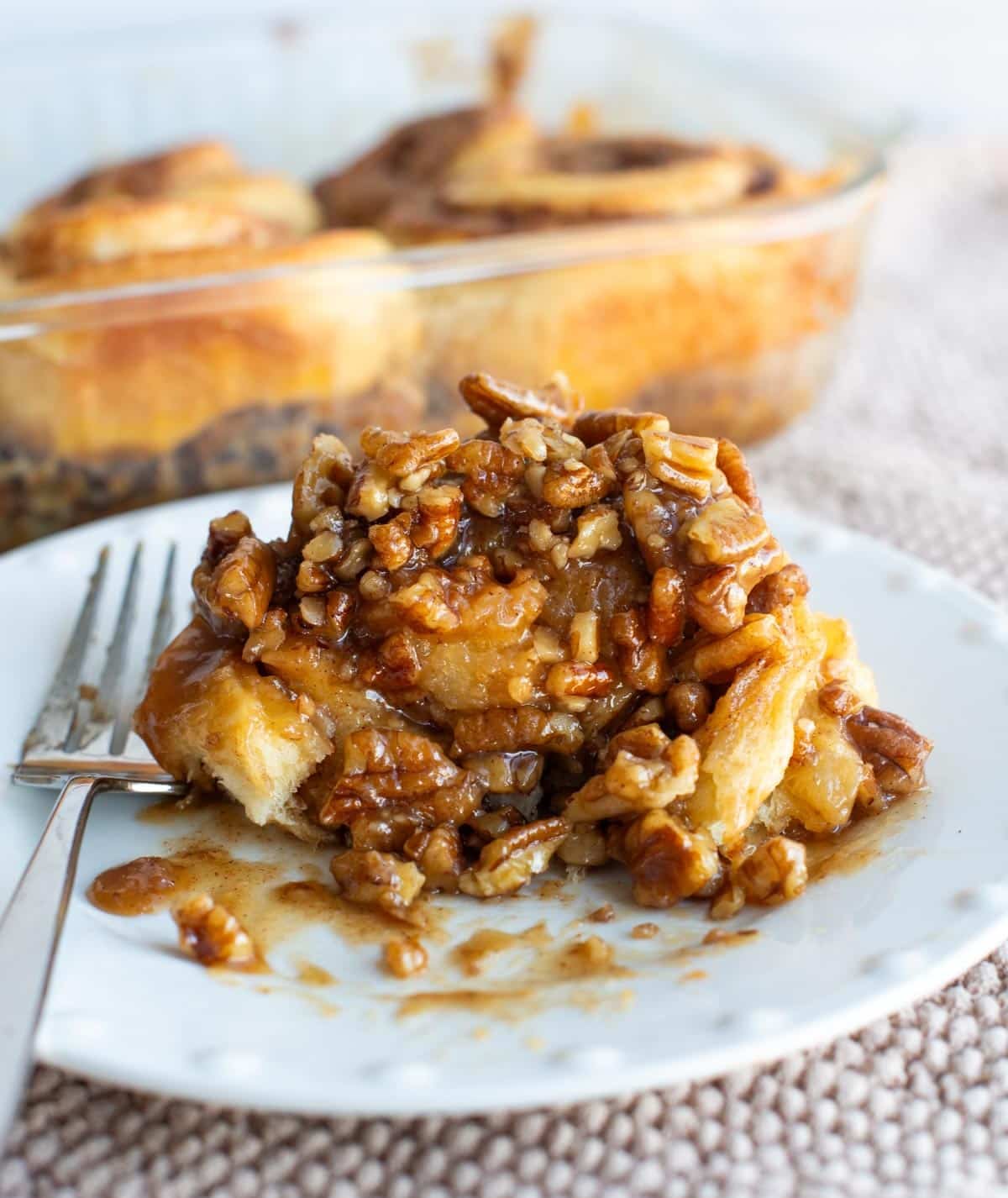 Sourdough sticky bun on a plate with a fork.