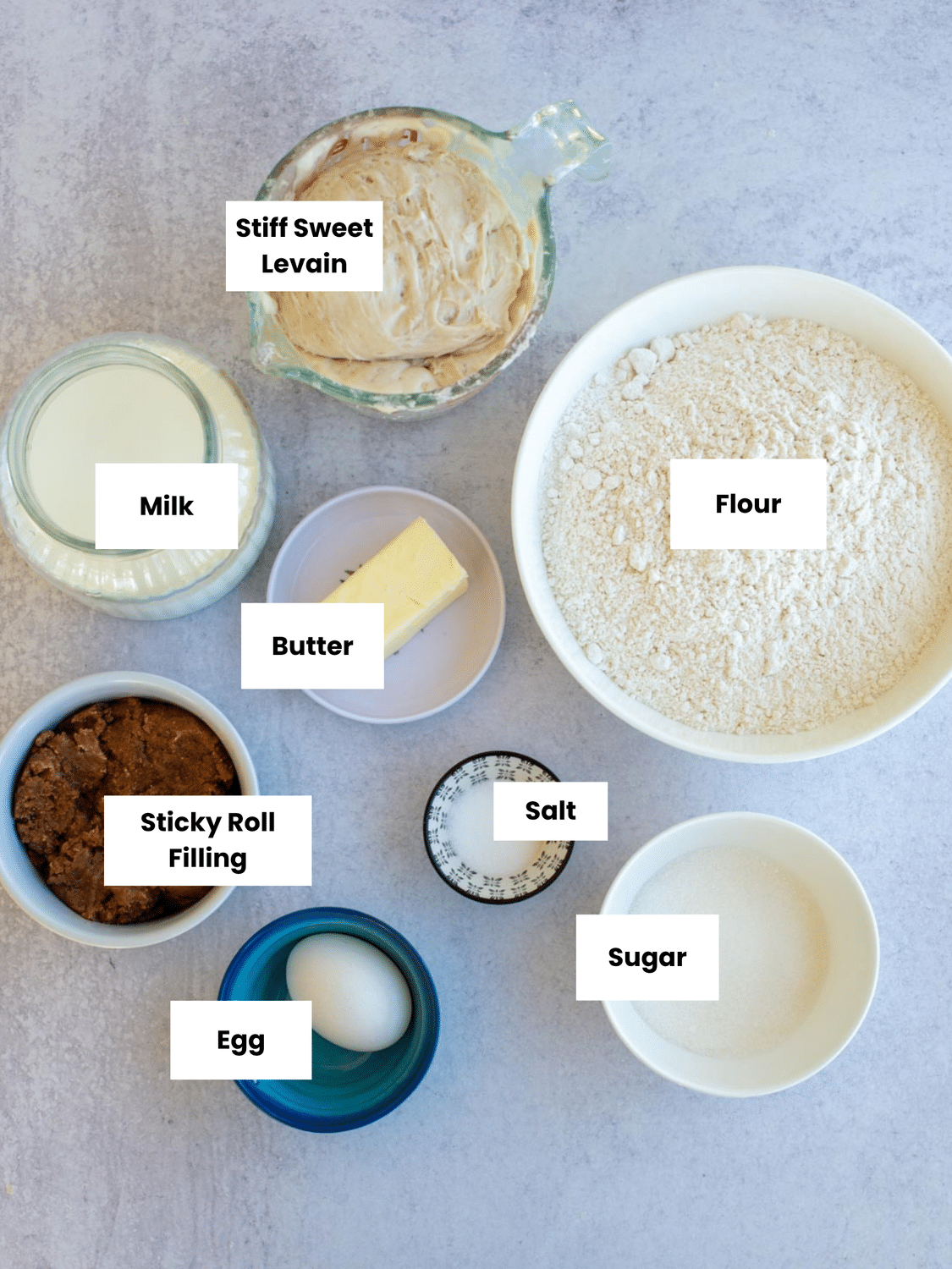 Ingredients for sourdough sticky buns labeled on a countertop.