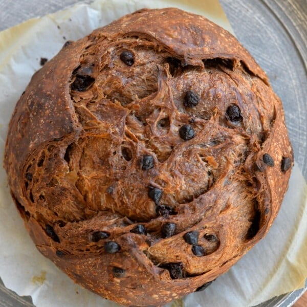 A loaf of chocolate croissant sourdough on parchment paper.