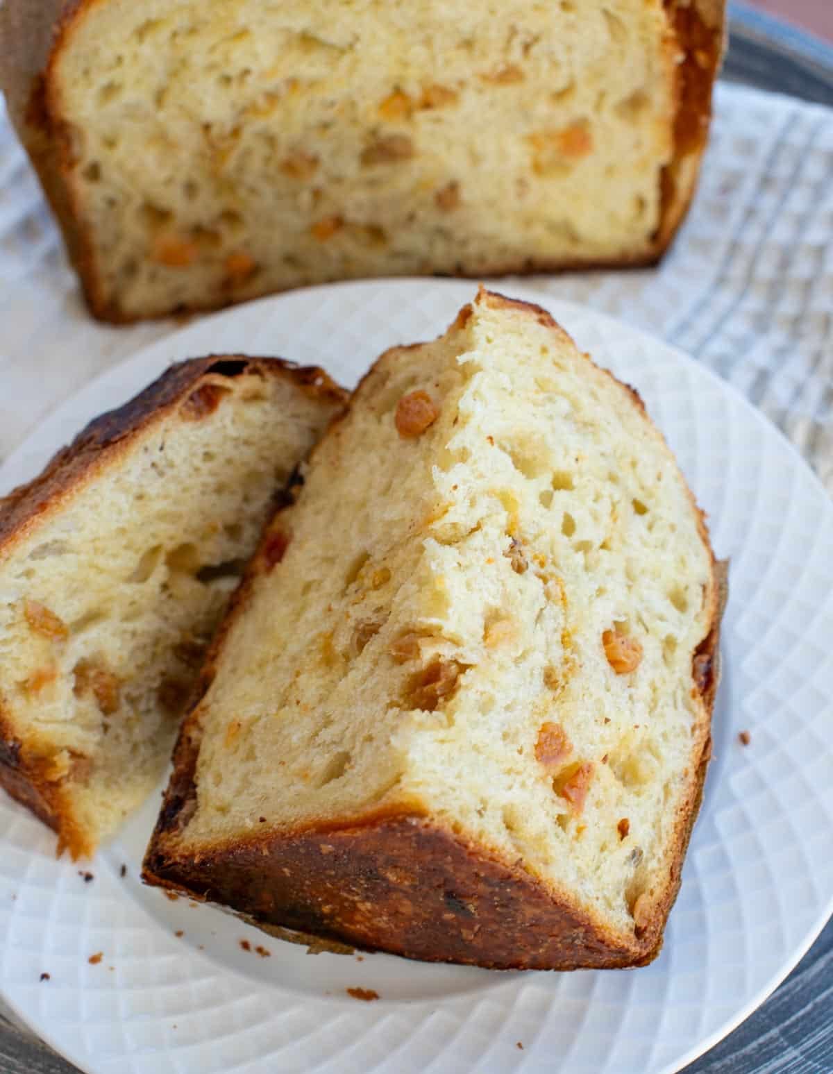 A quartered slice of sourdough panettone reveals candied fruits and an airy rise on the inside.