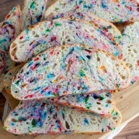 Funfetti Sourdough bread sliced and on top of a cutting board.