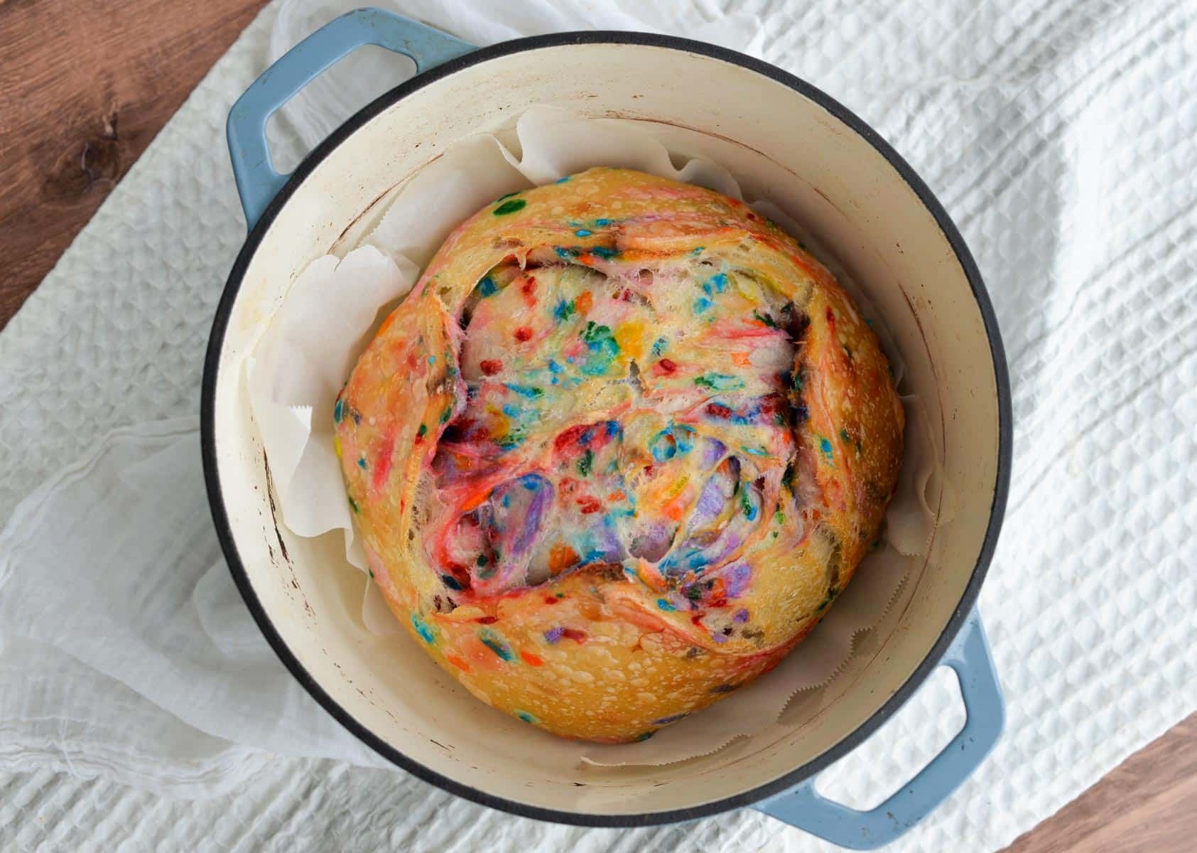 A colorful loaf of sourdough bread sits in a Dutch oven.