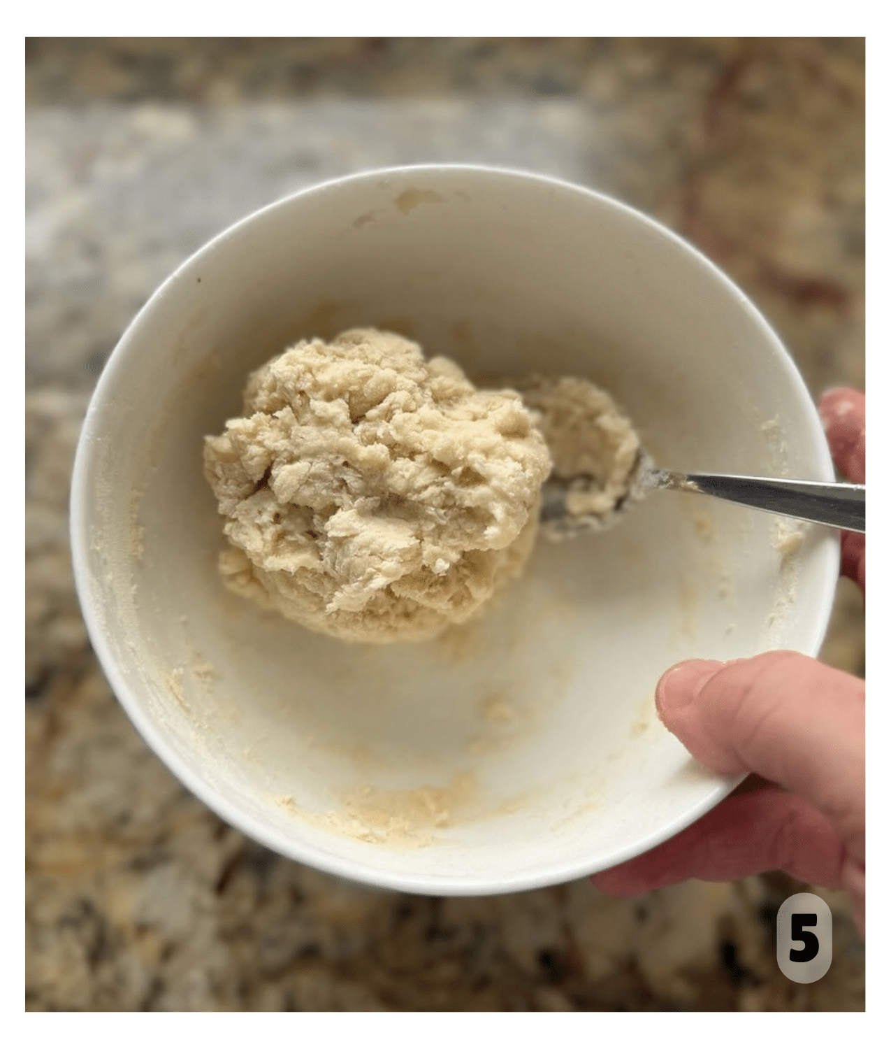 A round thick ball of dough sits in a bowl.