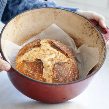Sourdough bread in a dutch oven on a countertop.